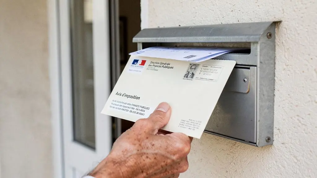 Personne recevant une enveloppe officielle de l'administration fiscale française à son domicile